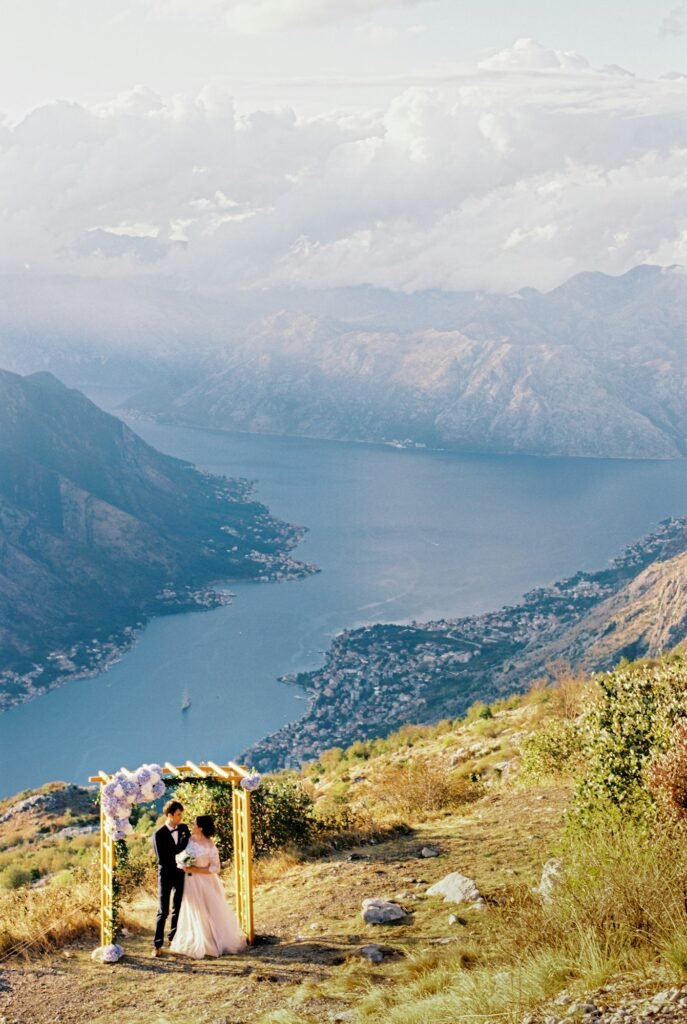 Groom and bride at the wedding arch on the mountain above the Kotor Bay